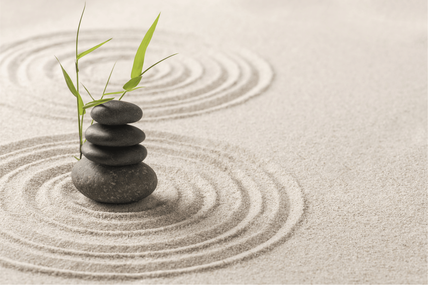 Zen stones stacked on sand representing balance and harmony, ideal for supporting emotional clarity and natural well-being.